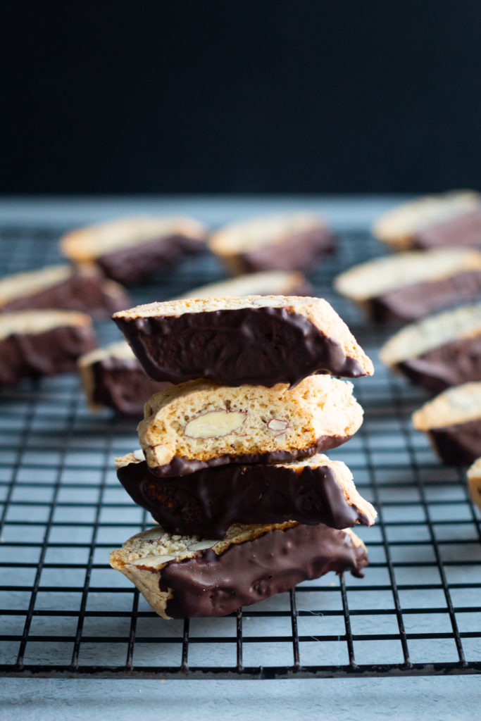 Chocolate almond biscotti stacked on cooling rack