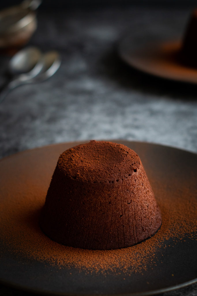 Mini Chocolate Lava Cake on a plate dusted in cocoa powder