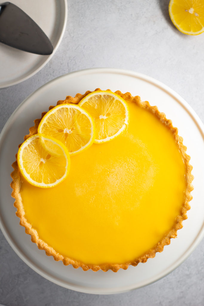 Aerial view of lemon tart garnished with 3 slices of lemon