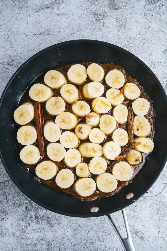 Sliced bananas in caramel in a frying pan