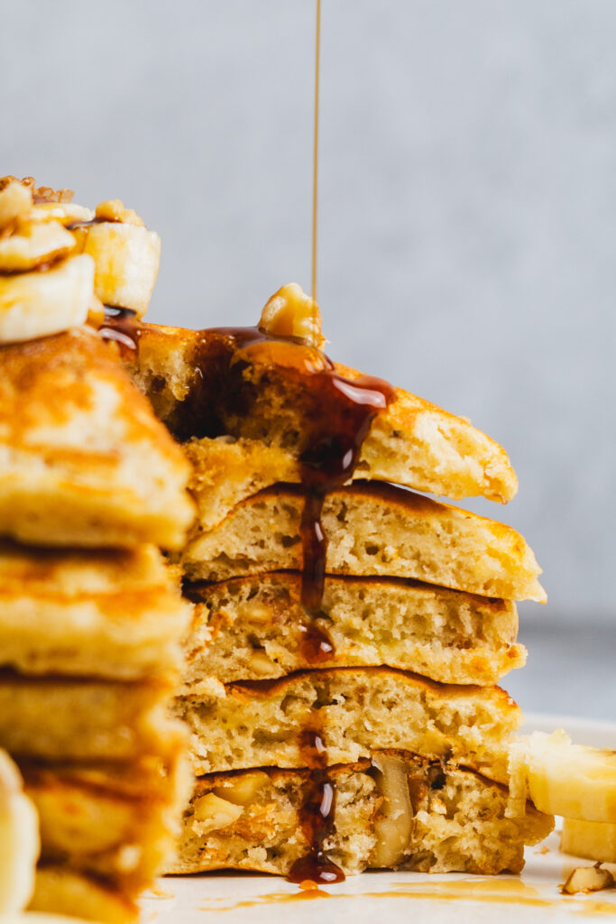 Close up of Banana walnut pancakes drizzled with maple syrup