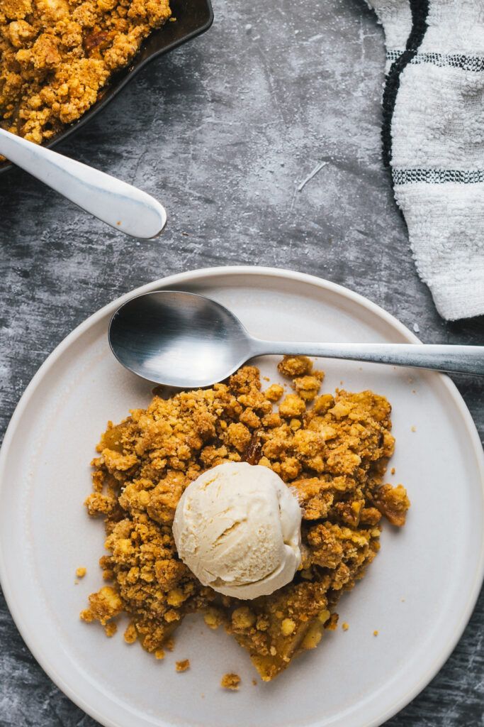 Apple Crisp on a plate topped with vanilla ice cream