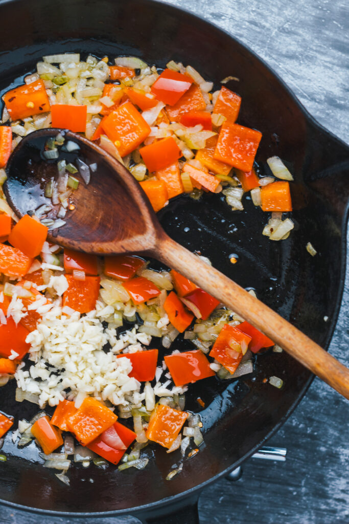 Peppers onions and garlic in a frying pan