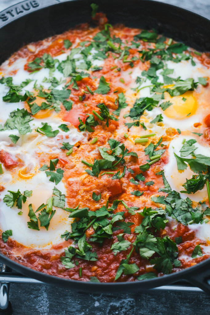 Moroccan Shakshuka in a frying pan with herbs on top