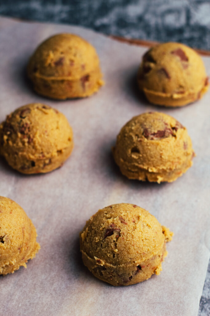 cookie dough portions on a sheet of greaseproof paper