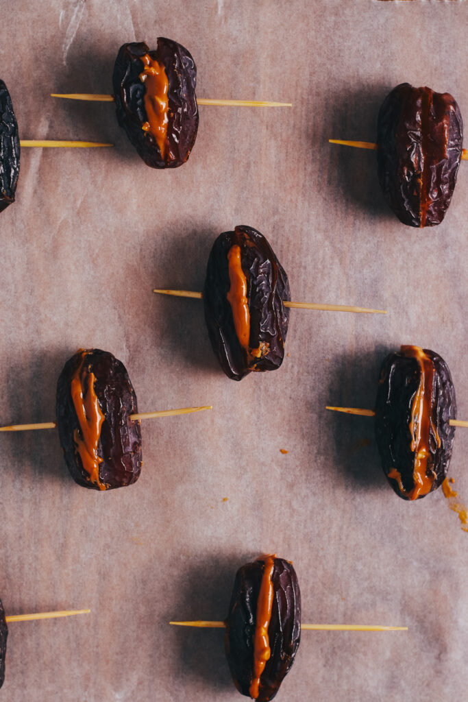 Snickers bites stuffed with peanut butter and pierced with cocktail sticks