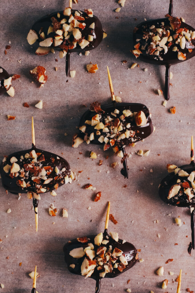 Stuffed dates covered in chocolate and topped with chopped almonds