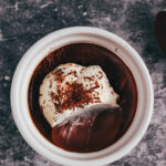 Chocolate pots de creme with a spoonful removed
