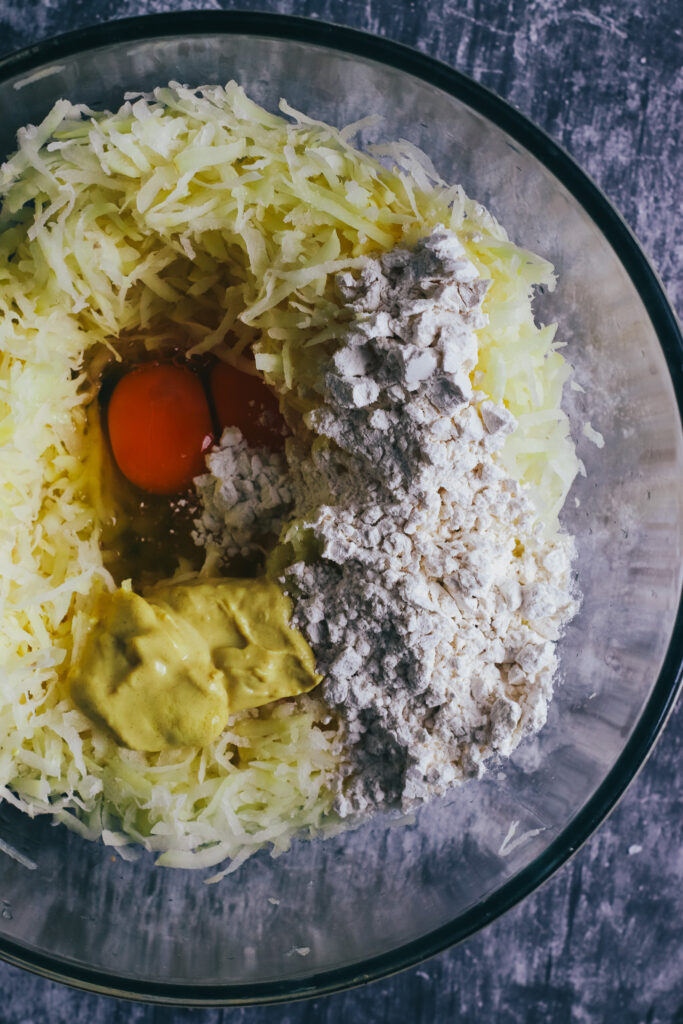 Grated potato, egg, flour and garlic in a bowl