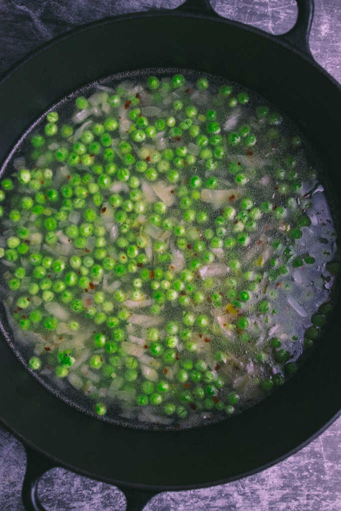 Onions, peas and water in a pot
