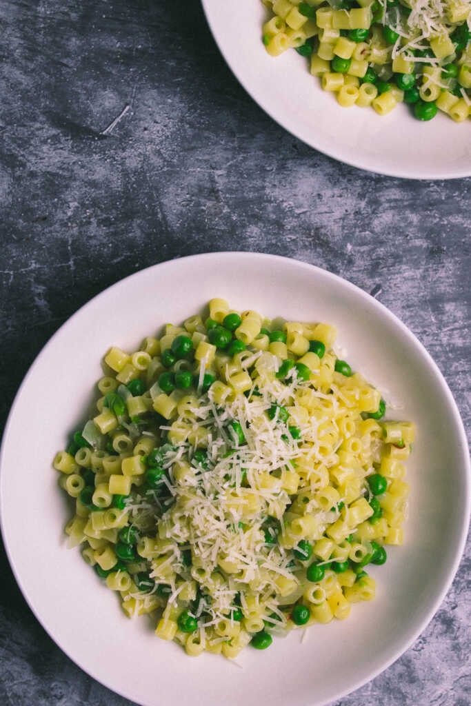 two bowls of Italian Pasta and Peas topped with grated parmesan