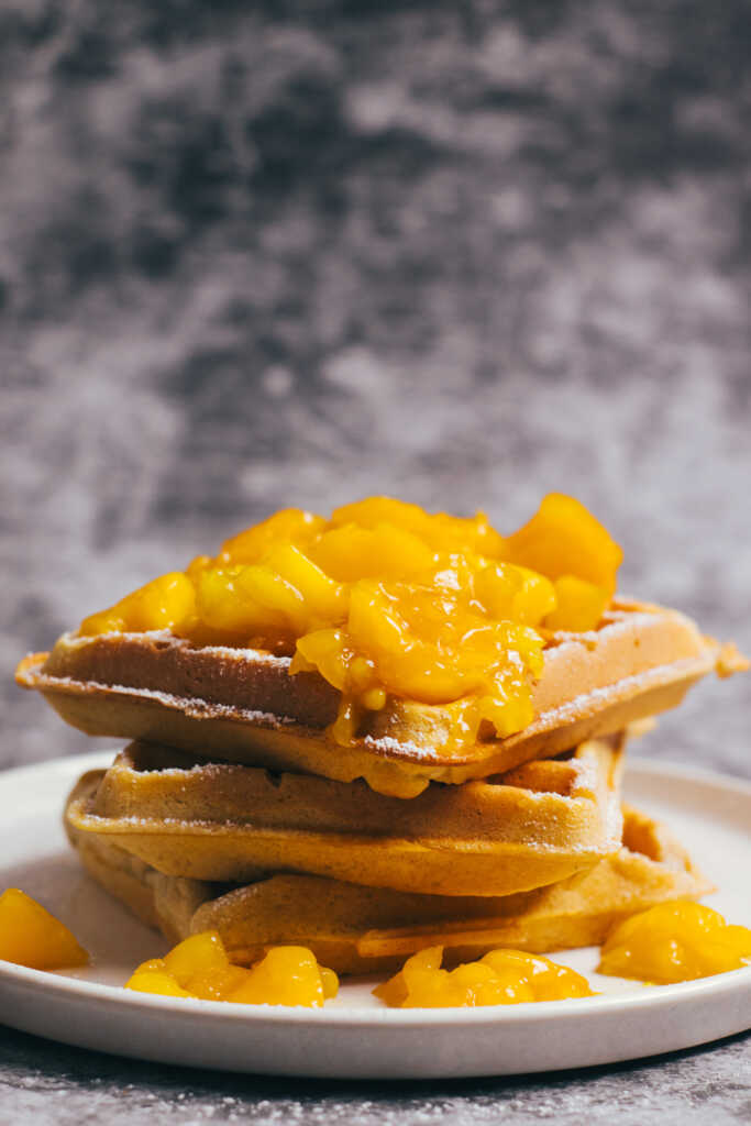 Stack of waffles topped with mango compote