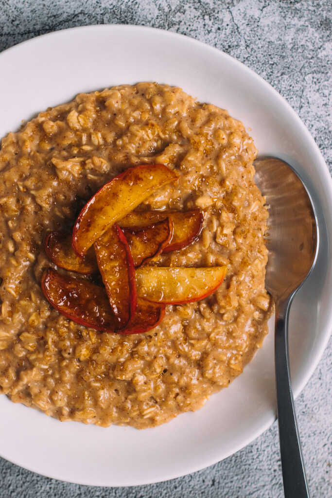 Apple pie porridge in a bowl with a spoon