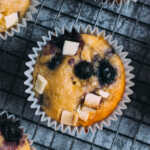 Close up of a white chocolate and blueberry muffin on a cooling rack