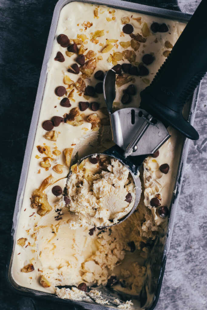 Coffee crumble ice cream with ice cream scoop in a container
