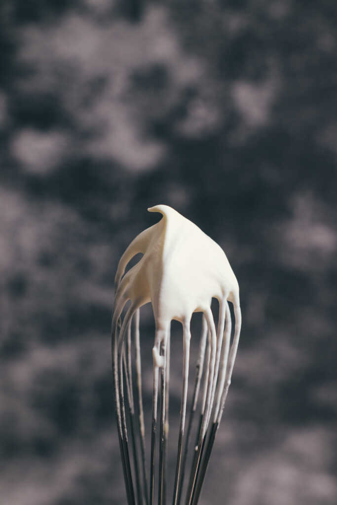 Whipped cream whipped to soft peaks on the end of a whisk