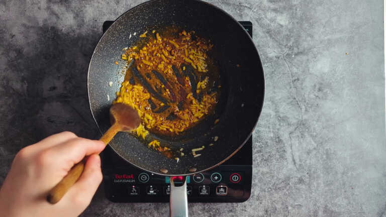 onions and spices in a frying pan