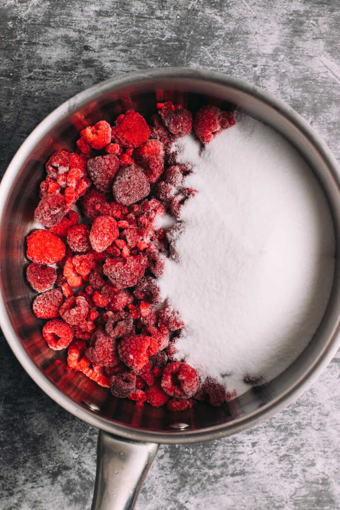 Raspberries and sugar in a saucepan