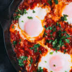 Moroccan Shakshuka in a frying pan with herbs on top