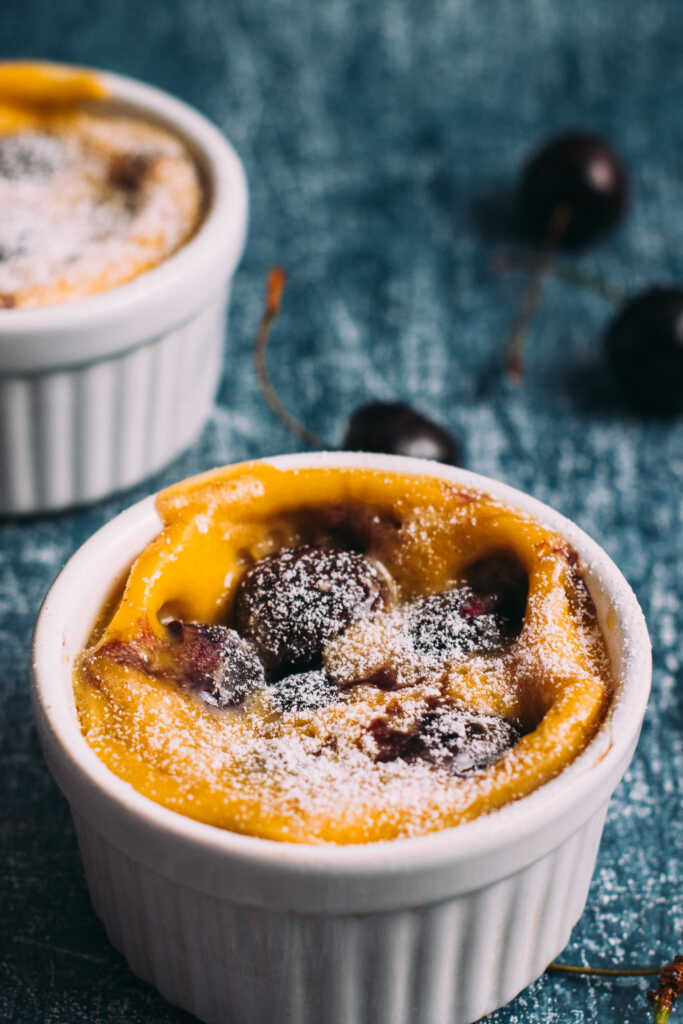 Easy Mini Clafoutis in a ramekin surrounded by cherries