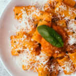 Tomato butter pasta in a bowl topped with grated parmesan