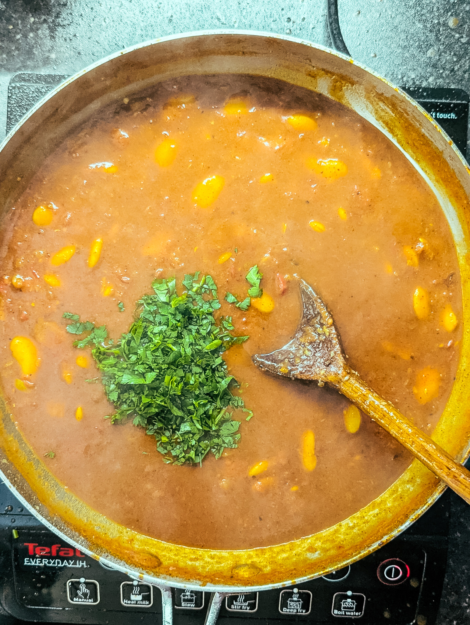 coriander added to ras el hanout curry in a frying pan