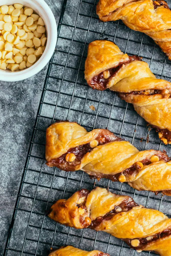 White chocolate and raspberry jam chocolate torsades on a cooling rack, golden and flaky