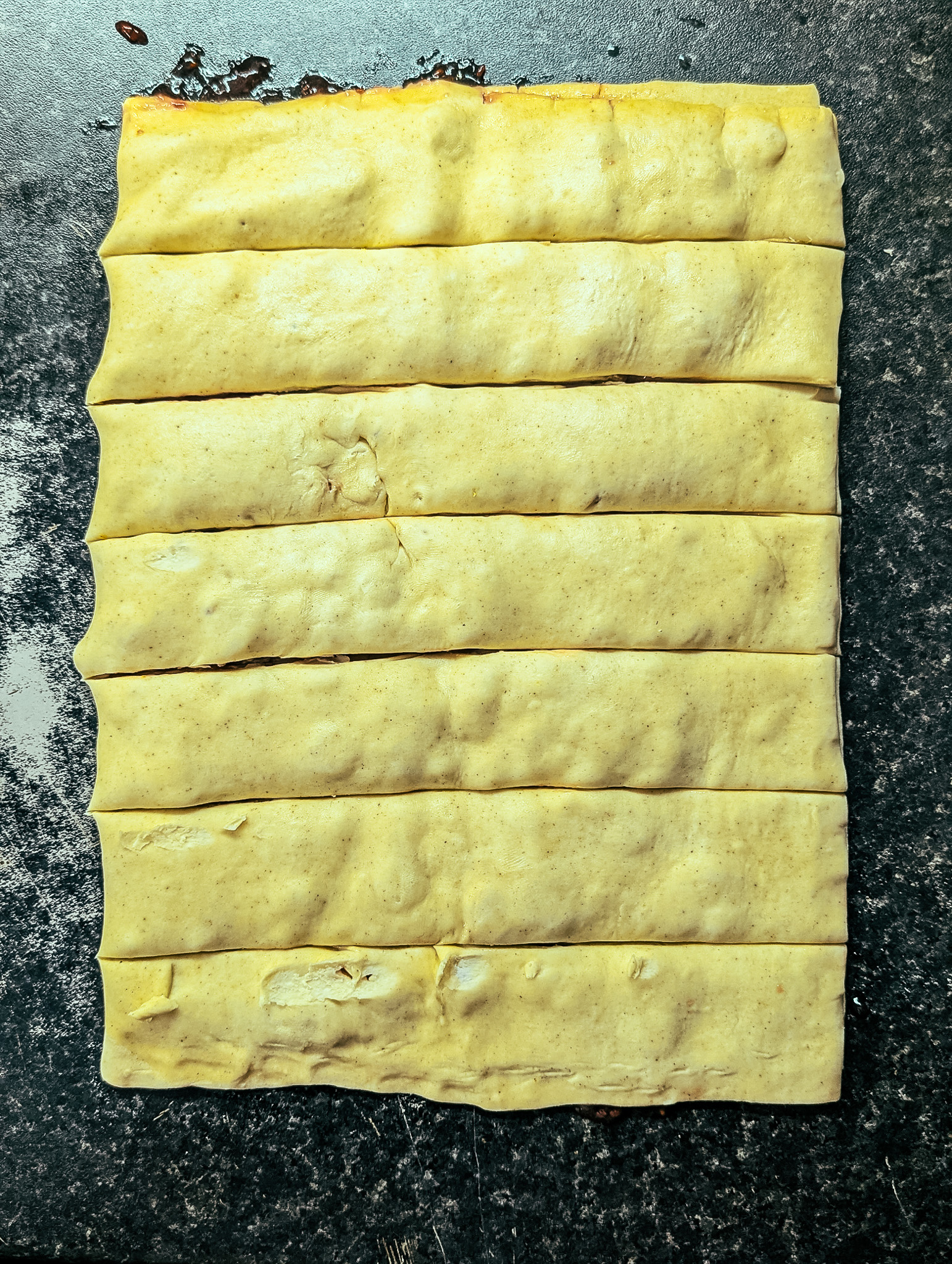 Puff pastry folded and sliced into strips, ready to twist into raspberry and white chocolate twists.
