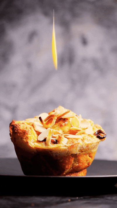 Animated GIF showing custard sauce being poured over a brioche bread and butter pudding