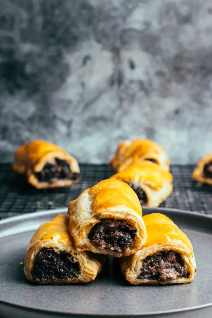 Stack of black pudding sausage rolls on grey plate