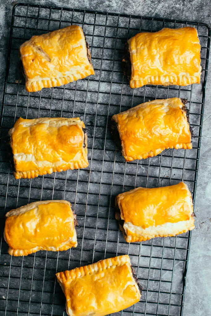 Tray of baked black pudding sausage rolls on cooling rack