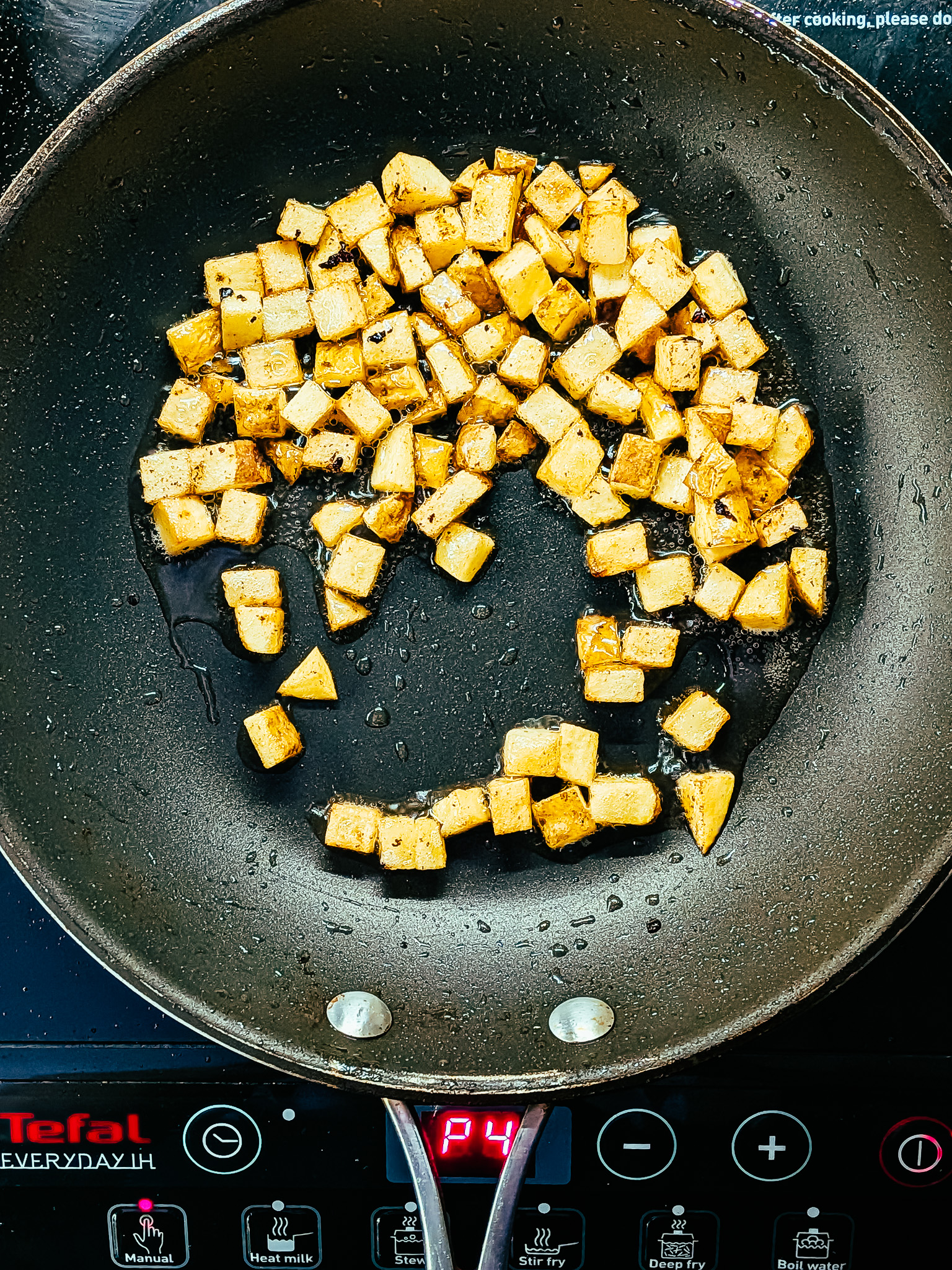 Golden diced potatoes frying in a pan, being cooked for a rustic country omelette