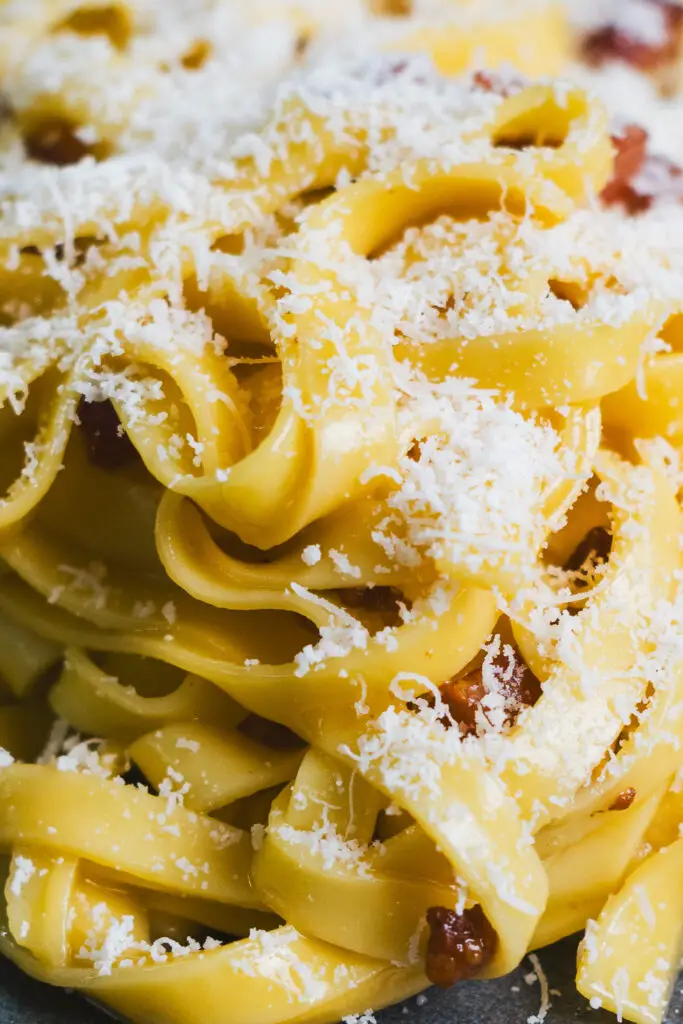 Close-up of silky tagliatelle carbonara with pancetta and grated cheese