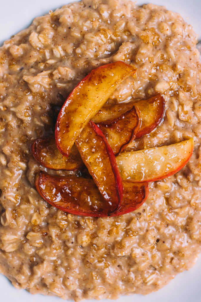 Detail shot of apple pie oatmeal topped with sticky caramelised apple slices
